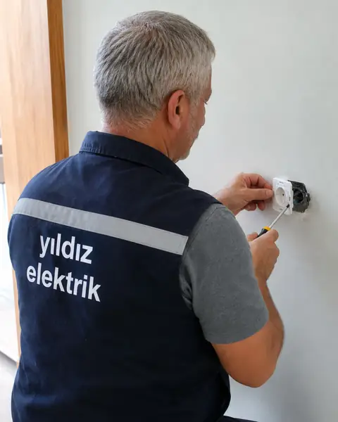 Yıldız Elektrik ustası duvardaki prizi değiştiriyor
